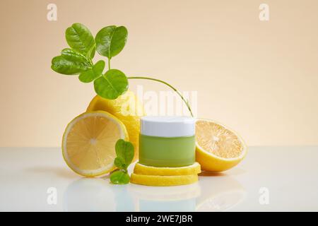 Vista frontale di una vaschetta senza etichetta posizionata su fette di limone su un tavolo bianco con riflessi. Il limone (Citrus limon) è una ricca fonte di vitamina C e antio Foto Stock