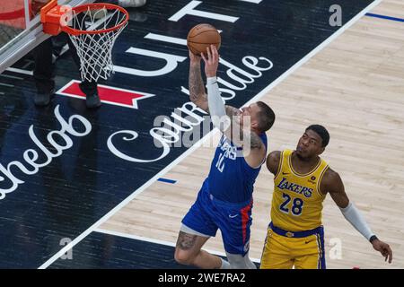 Los Angeles, USA. 23 gennaio 2024. Pallacanestro, NBA Professional League, Los Angeles Clippers - Los Angeles Lakers, round principale, crypto.com Arena. Il giocatore nazionale di basket Daniel Theis dei Los Angeles Clippers (l) segna un canestro contro Rui Hachimura. Credito: Maximilian Haupt/dpa/Alamy Live News Foto Stock