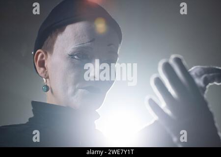 Ritratto di primo piano di un triste artista mimo con trucco a strappo che si esibisce emotivamente sul palco in retroilluminazione Foto Stock