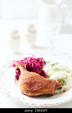 Anatra arrosto con cavolo rosso e purè di patate su sfondo luminoso. Primo piano. Foto Stock