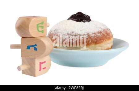 Festa di Hanukkah. Dreidels di legno con lettere ebraiche e ciambelle isolate su bianco Foto Stock