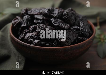 Prugne secche dolci nel recipiente sul tavolo, primo piano Foto Stock