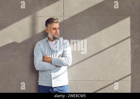 Ritratto di uomo d'affari maturo fiducioso bearded su sfondo grigio parete. Foto Stock