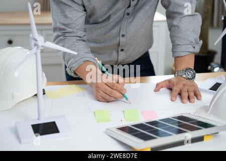 Uomini d'affari con pannello solare sulla scrivania in ufficio. Foto Stock