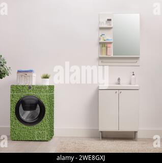 Lavatrice verde a risparmio energetico in un bagno vicino a un lavandino Foto Stock