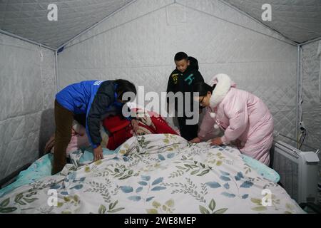 (240124) -- AKQI, 24 gennaio 2024 (Xinhua) -- Una famiglia fa letto all'interno di una tenda in un sito di reinsediamento nella contea di Akqi, nella regione autonoma di Xinjiang Uygur della Cina nord-occidentale, 23 gennaio 2024. La Cina ha stanziato fondi di soccorso per un totale di 30 milioni di yuan (4,23 milioni di dollari USA) dopo un terremoto di magnitudo 7,1 ha colpito la contea di Wushi, prefettura di Aksu, nella regione autonoma Xinjiang Uygur della Cina nordoccidentale martedì. I fondi, assegnati congiuntamente dal Ministero delle Finanze e dal Ministero della gestione delle emergenze, sarà utilizzato per sostenere i soccorsi in caso di catastrofi e i lavori di soccorso di emergenza, concentrandosi sulla ricerca e Foto Stock