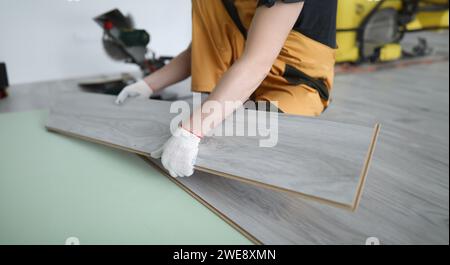 Repairman sostituisce l'appartamento con pannelli laminati Foto Stock