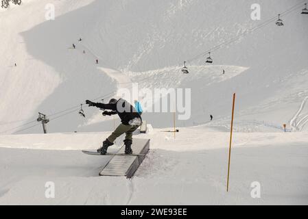 Trucchi per lo Snow Park. Snowboarder nel parco su una scatola. Jibbing invernale nello snwopark in Francia.. Foto Stock