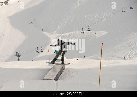 Trucchi per lo Snow Park. Snowboarder nel parco su una scatola. Jibbing invernale nello snwopark in Francia.. Foto Stock