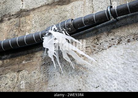 Acqua ghiacciata dopo lo scoppio di un tubo in inverno. Foto Stock