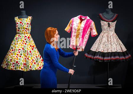 Un assistente della galleria colloca una blusa Jayson Classics in cotone stampato negli anni '1950 accanto a una mostra di abiti, sempre degli anni '1950, durante l'anteprima stampa di Andy Warhol: The Textiles ai Dovecot Studios di Edimburgo. La mostra mostra mostra le opere tessili recentemente riscoperte dall'artista pop americano, che rappresentano la prima opportunità per il pubblico di vedere queste opere in Scozia. Data foto: Mercoledì 24 gennaio 2024. Foto Stock