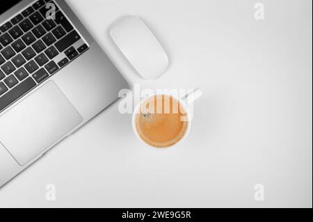 Vista dall'alto del notebook grigio su sfondo bianco. Tazza da caffè, mouse bianco, base piatta, spazio per le copie. Foto Stock