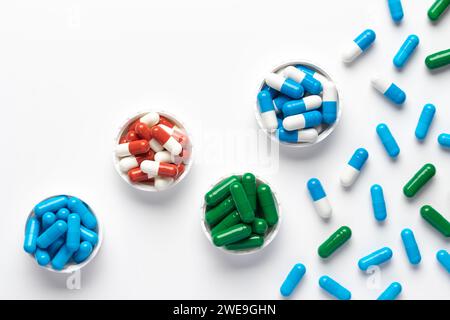 Integratori alimentari e diverse vitamine, varie pillole colorate su sfondo bianco, capsule mediche farmaceutiche assortite da vicino, vista dall'alto, Foto Stock