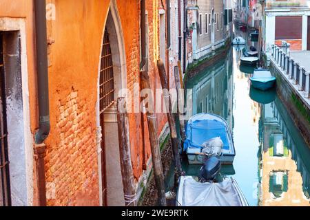 Stretto canale d'acqua con barche a Venezia Foto Stock