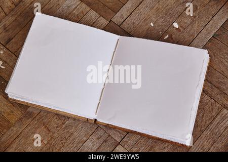 Libro bianco artigianale su legno di spina di pesce, vista dall'alto Foto Stock
