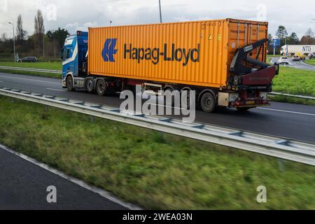 Amsterdam, Paesi Bassi - 7 dicembre 2022: Un camion in autostrada con un contenitore Hapag-Lloyd *** Ein LKW auf der Autobahn mit einem Hapag-Lloyd Foto Stock