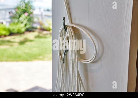 White Rope on Door Hook nella Sunny Suburban Home Foto Stock