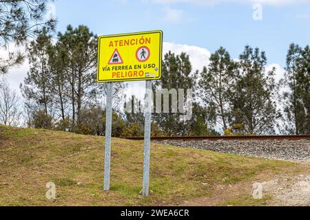 Un Ponte Ulla, Spagna. Segnale stradale che indica un messaggio di avvertenza davanti a un binario ferroviario Foto Stock