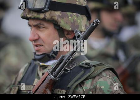 Bucarest, Romania - 24 gennaio 2024: Dettagli con un soldato dell'esercito rumeno in possesso di un fucile d'assalto AK 47 durante una cerimonia militare presso il monumento Foto Stock