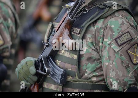 Bucarest, Romania - 24 gennaio 2024: Dettagli con un soldato dell'esercito rumeno in possesso di un fucile d'assalto AK 47 durante una cerimonia militare presso il monumento Foto Stock