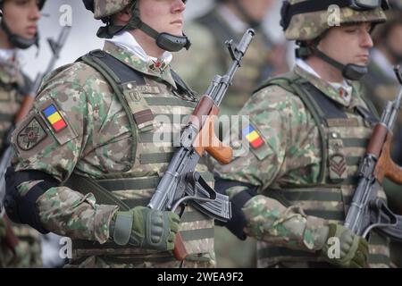Bucarest, Romania - 24 gennaio 2024: Dettagli con un soldato dell'esercito rumeno in possesso di un fucile d'assalto AK 47 durante una cerimonia militare presso il monumento Foto Stock