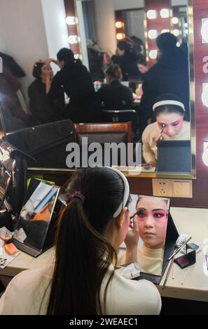 WUHAN, 24 gennaio 2024 (Xinhua) -- un'attrice dell'Opera di Chuju si fa il trucco a Wuhan, nella provincia di Hubei, nella Cina centrale, 23 gennaio 2024. Dal 2016, al fine di riservare talenti per le opere, l'Hubei Drama Art Theatre ha selezionato e reclutato più di 150 studenti di Chuju Opera, Hanju Opera e Huangmei Opera, e ha affidato l'Hubei College of the Arts per la formazione direzionale. Dopo sette anni di studio dell'opera e un anno di stage, questo gruppo di giovani attori operistici salì sul palco del gala di laurea con le loro migliori rappresentazioni. (Xinhua/Du Zixuan) Foto Stock