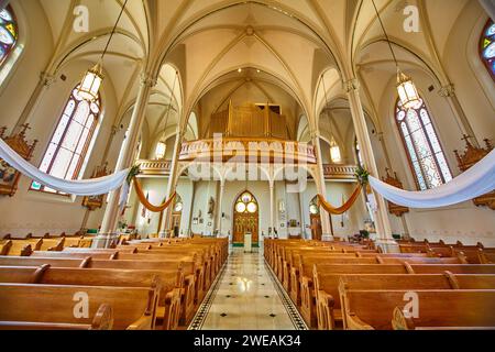 Interno della chiesa gotica con soffitto a volta e vetrate colorate, a livello degli occhi Foto Stock