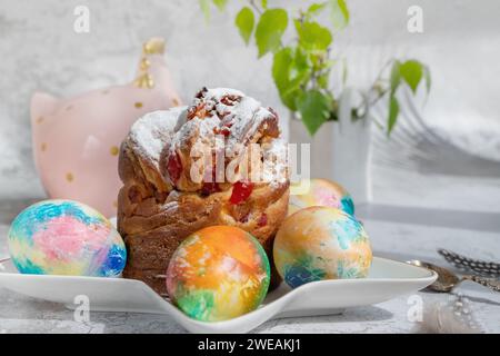 Buona pasqua. Statuette pasquali moderne, uova pasquali e fiori su un tavolo rustico. Elegante arredamento per tavoli da vacanza. Uova di Pasqua colorate naturalmente e primavera Foto Stock