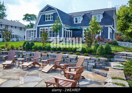 Oasis del cortile suburbano con caminetto e sedie Adirondack Foto Stock