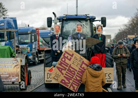 Berlino, Deutschland, DEU - Bauerndemonstration gegen die Agrarpolitik der Bundesregierung 15.01.2024, Berlino, Deutschland, DEU - Bauerndemonstration gegen die Agrarpolitik der Bundesregierung. Landwirte, Handwerker, Spediteure und Angehörige des Transportgewerbes demonstrieren mit ihren Traktoren und Lastkraftwagen auf der Straße des 17. Juni. Protesta dell'IHR richtet sich gegen die Abschaffung des subventionierten Agrardiesels und die Aufhebung der Kfz-Steuerbefreiung für Landwirte. Ein kind steht mit einem Plakat mit der Aufschrift: Die Ampel raubt mir meine Zukunft vor einem Traktor, der Schaufe Foto Stock