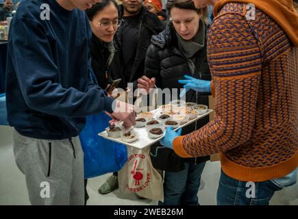 Ai clienti e ai potenziali clienti viene offerta una pasticceria gratuita che celebra l'inaugurazione di una filiale del Capital One Cafe in Herald Square a New York sabato 20 gennaio 2024. Oltre ad avere una filiale della banca sepolta all'interno, l'invitante caffetteria serve cibo e bevande e funge da spazio di co-working, che tu sia un cliente o meno. (© Richard B. Levine) Foto Stock