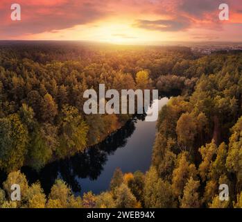 Splendido paesaggio suggestivo del lago nella foresta autunnale sullo sfondo del cielo al tramonto. Paesaggio autunnale da sogno. Foto Stock
