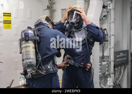 I marinai a bordo del cacciatorpediniere missilistico guidato classe Arleigh Burke USS Thomas Hudner (DDG 116) indossano attrezzature antincendio durante un'esercitazione per il controllo dei danni durante la navigazione Foto Stock