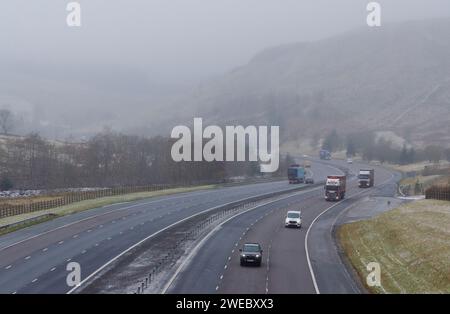 VICINO A MOFFAT, SCOZIA, Regno Unito - 16 gennaio 2024 - traffico sulla M74 vicino a Moffat oggi (lunedì), mentre la neve si muove verso sud spinto da un'esplosione artica che Foto Stock