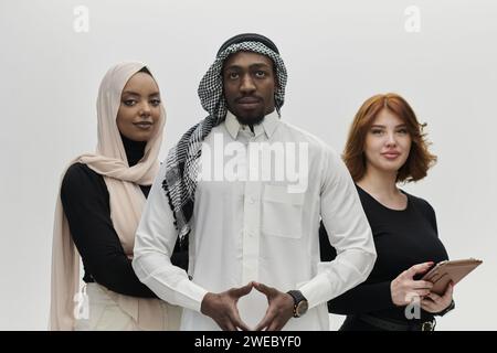 Un uomo d'affari arabo si affianca con fiducia a due donne d'affari, rappresentando un team pronto e diversificato che incarna ambizione, innovazione e Foto Stock