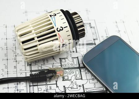 Smartphone, spina di rete e termostato del radiatore, immagine simbolica per Smart Home Foto Stock