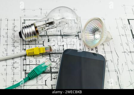 Spina di rete, lampade e smartphone sul disegno di costruzione, immagine simbolica per Smart Home Foto Stock