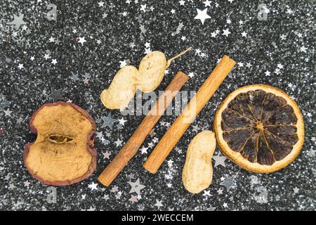 Bastoncini di cannella, arachidi e fetta di limone essiccato su stelle decoratioine, decorazione natalizia Foto Stock