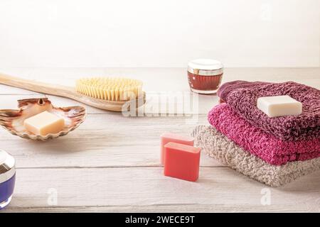 Accessori assortiti per il centro benessere, tra cui spazzola, sapone e lozione per il corpo disposti su una superficie di legno. Relax e cura di sé per bellezza e benessere Foto Stock