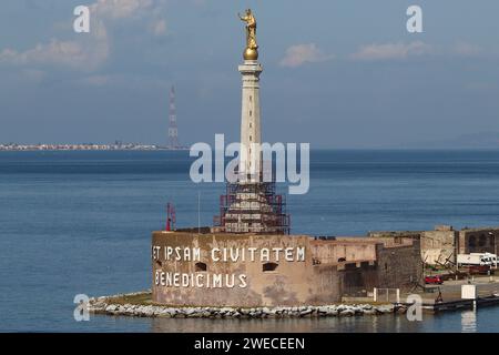 Statua della Madonna dorata al porto di Messina. Sullo sfondo, uno dei piloni di Messina che trasportava linee elettriche dall'Italia all'isola, 04/2023. Foto Stock