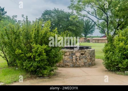 Vista laterale del vecchio pozzo d'acqua in pietra con copertura in legno nel parco pubblico della Corea del Sud Foto Stock