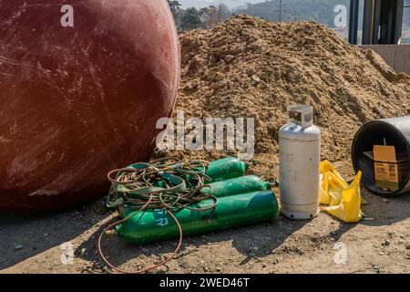 Chungju, Corea del Sud, 22 marzo 2020: Solo per uso editoriale. Serbatoi di ossigeno per saldatura e apparecchiature poste a terra accanto a un grande contenitore metallico nel punto Foto Stock