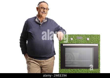 Uomo maturo sorridente appoggiato su una stufa a risparmio energetico isolata su sfondo bianco Foto Stock