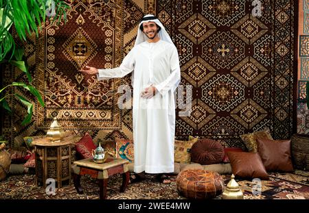 Uomo degli emirati che indossa un abito kandura trascorre del tempo in una casa tradizionale araba a Dubai Foto Stock