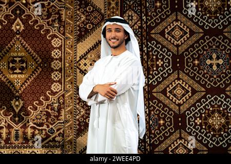 Uomo degli emirati che indossa un abito kandura trascorre del tempo in una casa tradizionale araba a Dubai Foto Stock