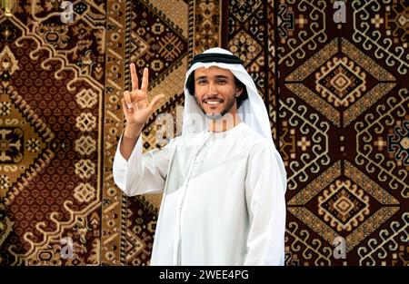 Uomo degli emirati che indossa un abito kandura trascorre del tempo in una casa tradizionale araba a Dubai Foto Stock
