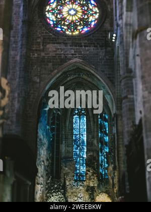 Una vista interna della Catedral-Basilica de Santa Maia a Palma de Mallorca, che mostra gli intricati dettagli gotici e le colorate vetrate colorate sotto la delicata luce serale. Foto Stock