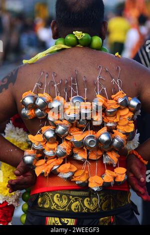 KUALA LUMPUR 25/01/2024. Thaipusam o Thaipoosam è un festival indù Tamil celebrato il primo giorno di luna piena del mese Tamil della Thailandia in coincidenza con la stella Pusam. Il festival è celebrato per commemorare la vittoria del dio indù Murugan sul demone Surapadman usando un palo, una lancia divina concessa da Parvati. Il festival include pratiche ritualistiche di Kavadi Aattam, un atto cerimoniale di sacrificio che porta un peso fisico come mezzo per bilanciare un debito spirituale. Gli adoratori spesso portano un vaso di latte vaccino come offerta e fanno anche mortificazione della carne perforando la pelle, la lingua Foto Stock