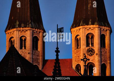 Brunswick, Germania. 2 novembre 2023. Le torri della Chiesa evangelica luterana La chiesa di Martin è illuminata dalla luce del sole che sorge; lo stemma della città, il "leone di Brunswick", può essere visto in primo piano sulla cima della fontana Marienbrunnen sull'Altstadtmarkt. Crediti: Stefan Jaitner/dpa/Alamy Live News Foto Stock