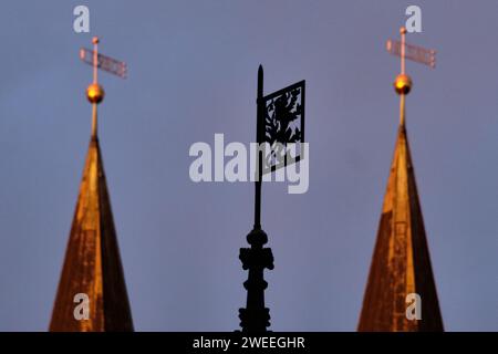 Brunswick, Germania. 2 novembre 2023. Le torri della Chiesa evangelica luterana La chiesa di Martin è illuminata dalla luce del sole che sorge; lo stemma della città, il "leone di Brunswick", può essere visto in primo piano sulla cima della fontana Marienbrunnen sull'Altstadtmarkt. Crediti: Stefan Jaitner/dpa/Alamy Live News Foto Stock